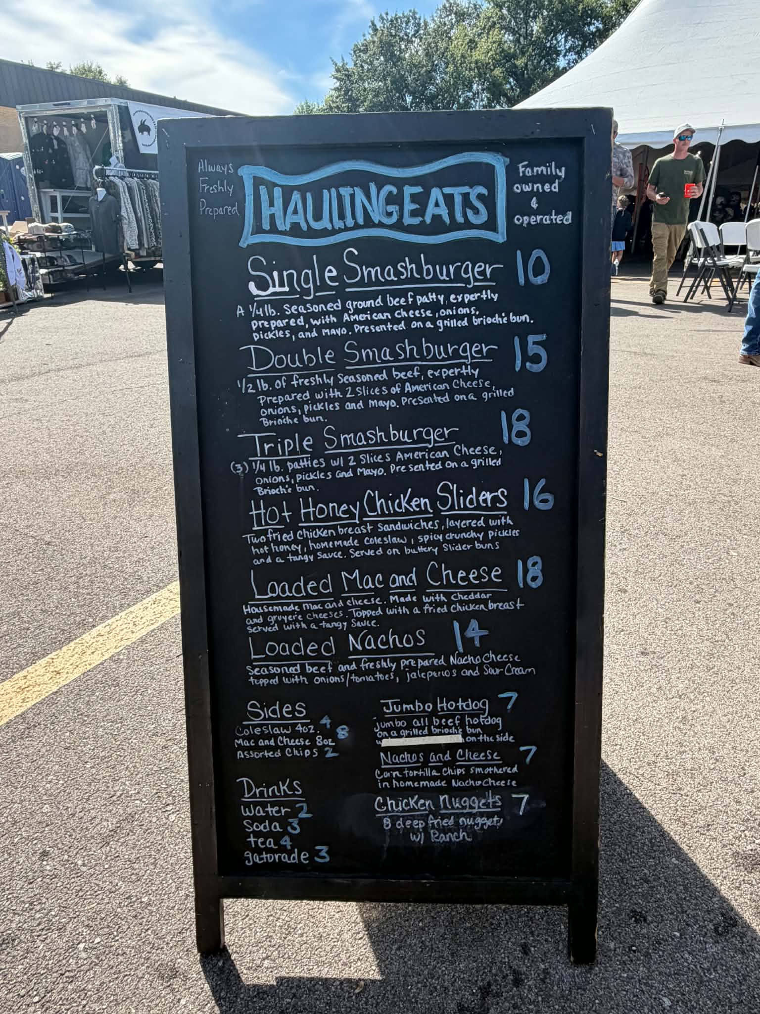 Hauling Eats chalkboard menu with smashburgers, hot honey chicken sliders, loaded mac and cheese, and loaded nachos