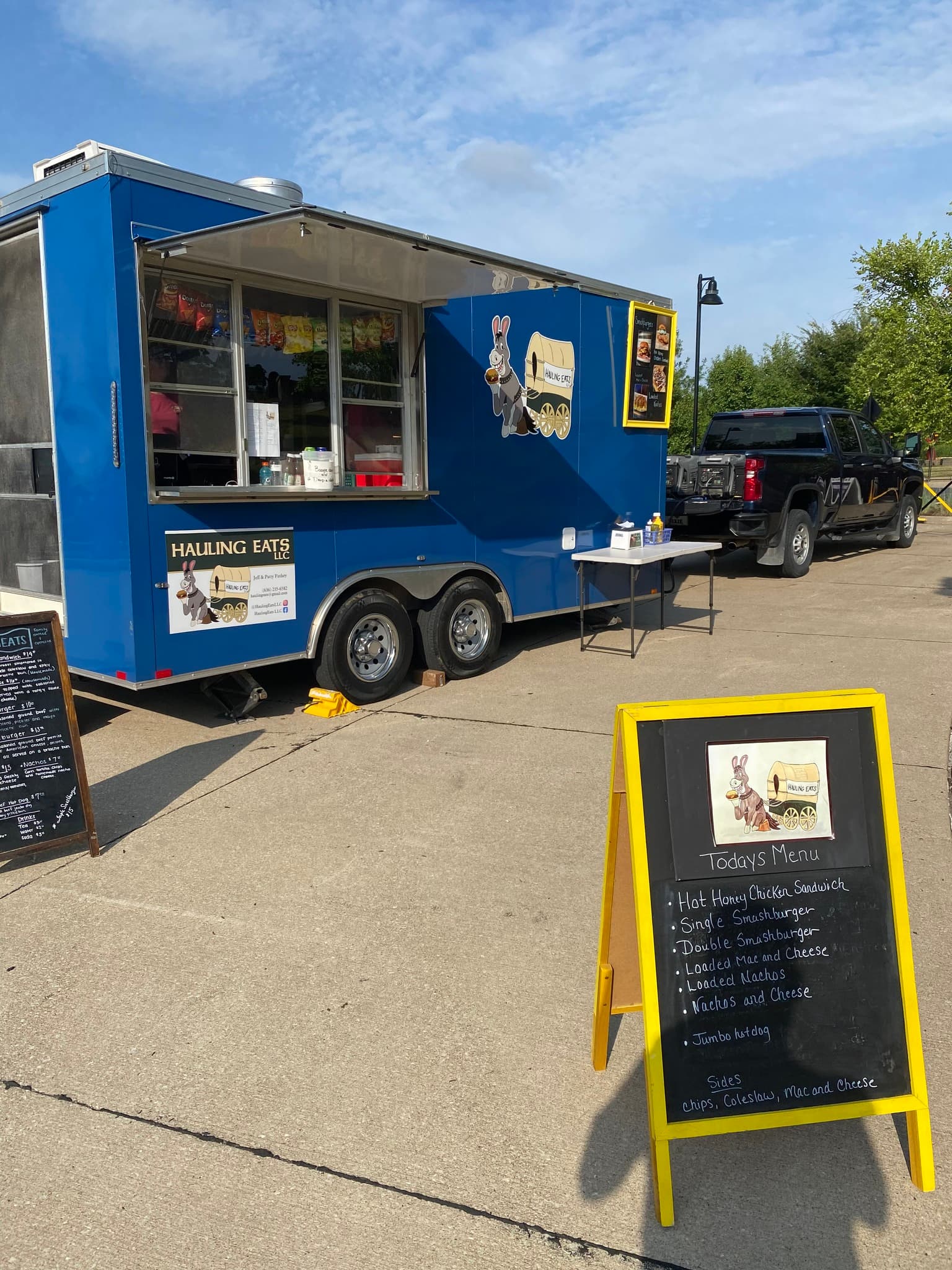 Hauling Eats trailer with a chalkboard menu board out front
