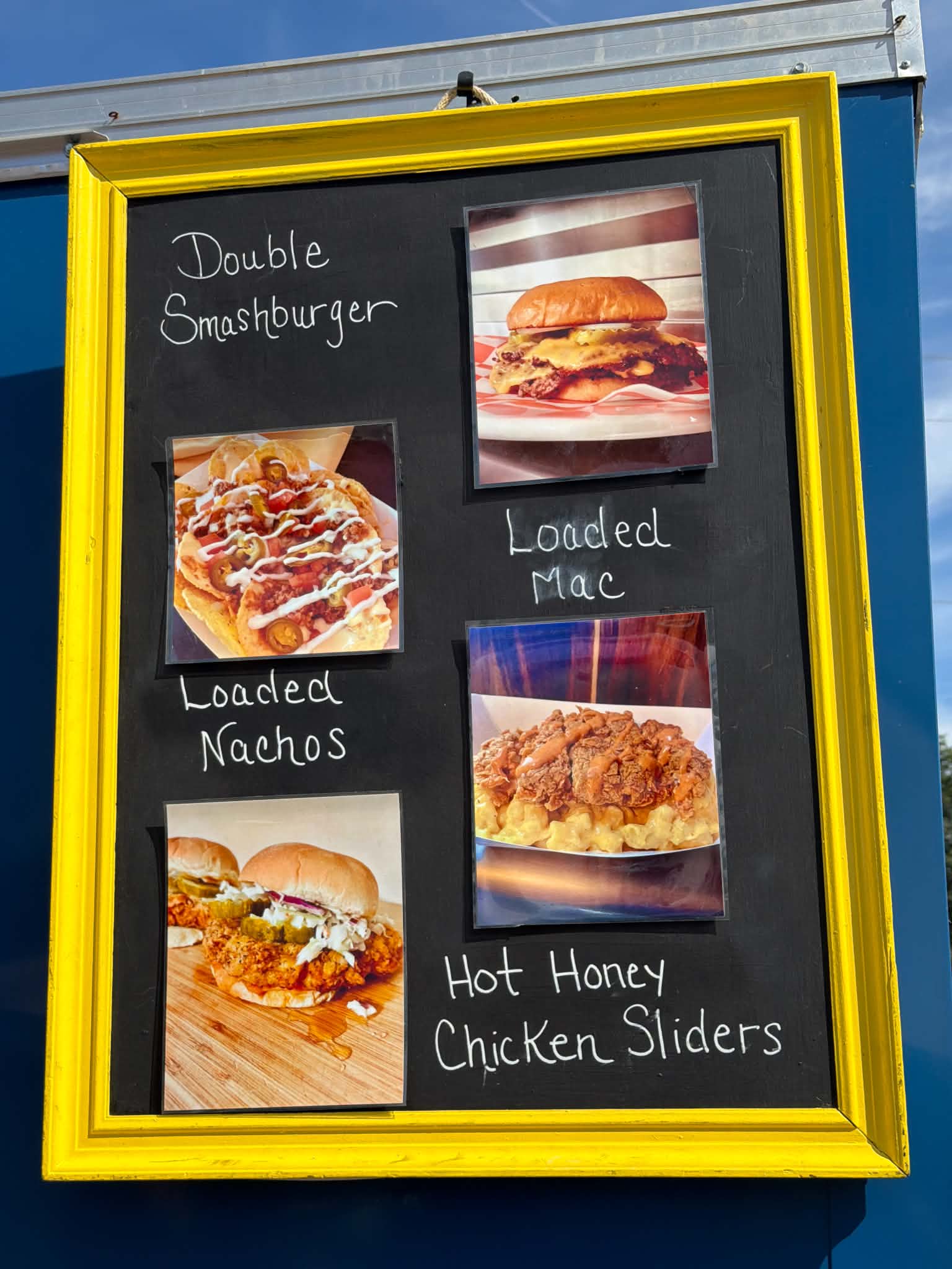 Photo board on the trailer: Double Smashburger, Loaded Nachos, Loaded Mac, and Hot Honey Chicken Sliders