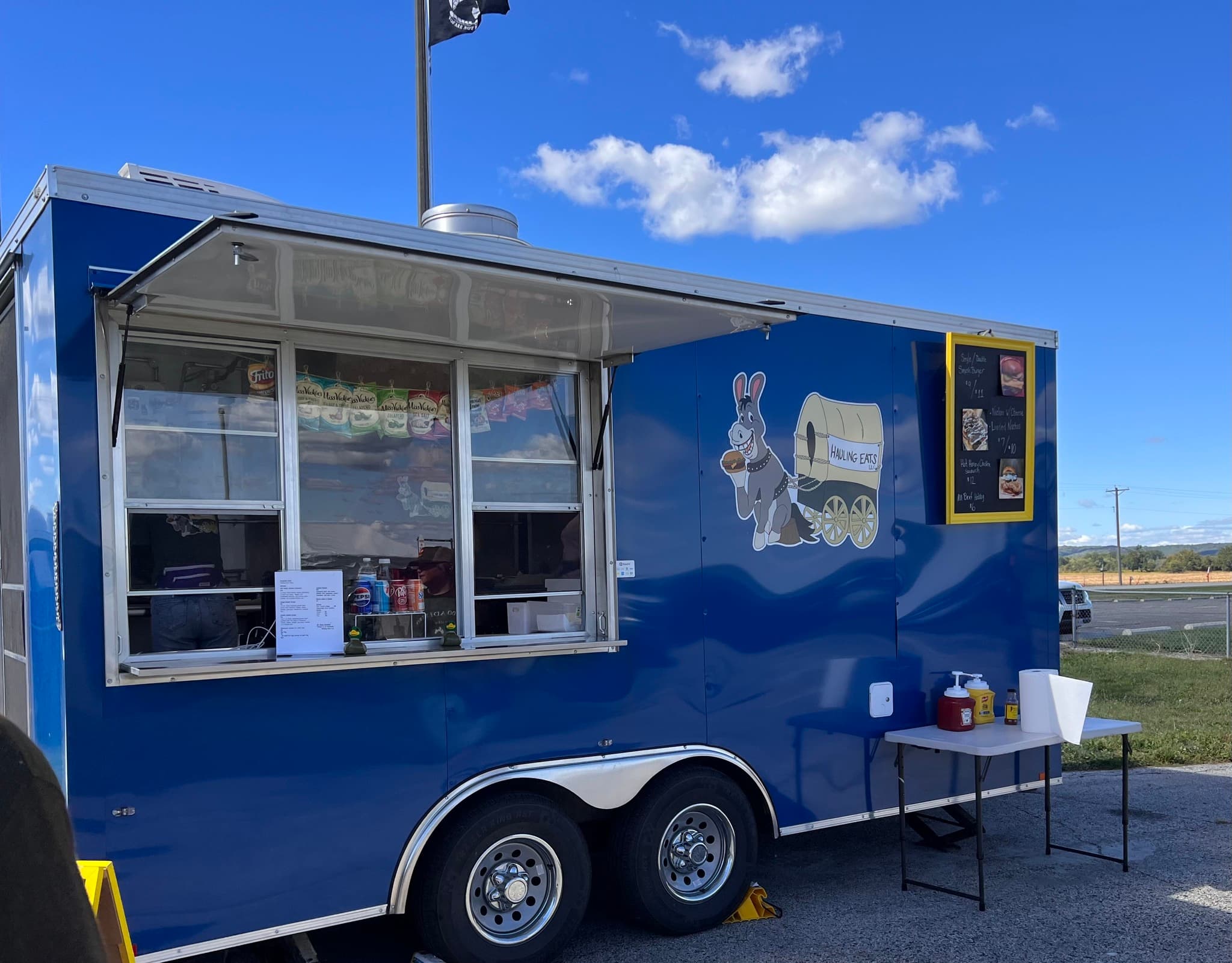 The Hauling Eats blue trailer set up at an event
